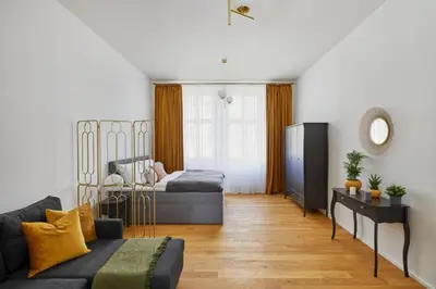 a living room with a couch and a bed at Modern & Elegant, 3 min of Wenceslas Square in Prague