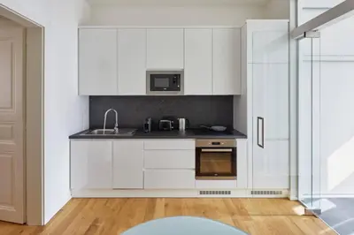 a white kitchen with a sink and a microwave at Modern & Elegant, 3 min of Wenceslas Square in Prague