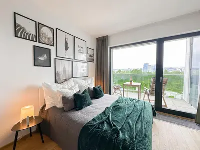 a bedroom with a large bed and a balcony at REAL Living by REFA Balcony Retreat 91 in Prague