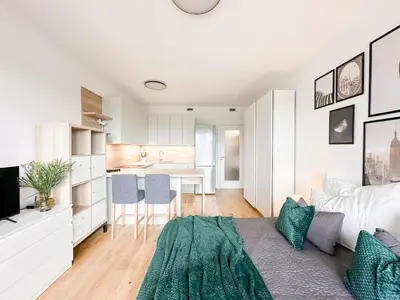 a living room with a couch and a kitchen at REAL Living by REFA Balcony Retreat 91 in Prague