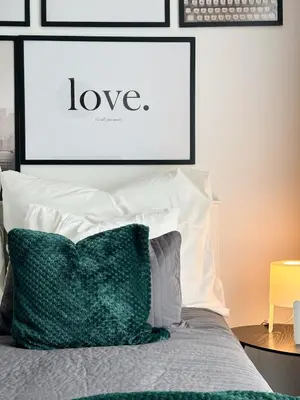 a bedroom with a bed with a framed picture of love at REAL Living by REFA Balcony Retreat 91 in Prague
