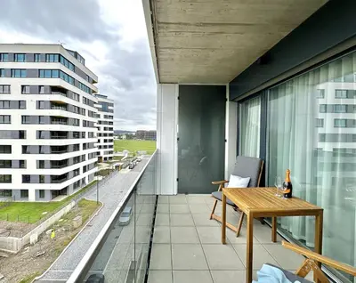 a balcony with a table and a view of a building at REAL Living by REFA Balcony Retreat 91 in Prague