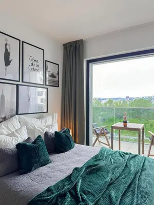 a bedroom with a bed and a large window at REAL Living by REFA Balcony Retreat 91 in Prague