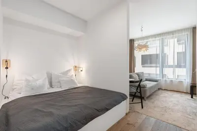 a bedroom with a bed and a chair and a window at REAL Living by REFA Karlin 307 in Prague