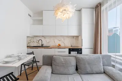 a living room with a couch and a kitchen at REAL Living by REFA Karlin 307 in Prague