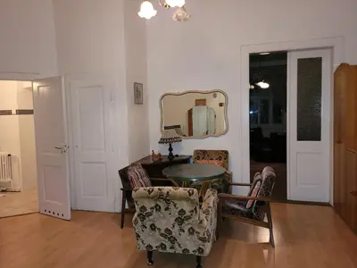 a living room with a table and chairs and a mirror at Bright 2BDR sleeps 8 near center M1 in Prague