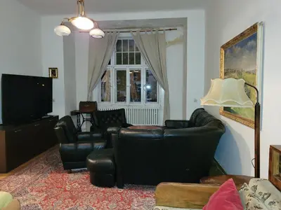 a living room with black leather furniture and a window at Bright 2BDR sleeps 8 near center M1 in Prague