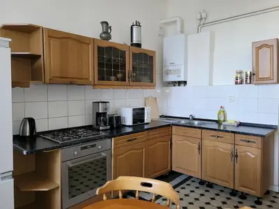 a kitchen with wooden cabinets and a stove top oven at Bright 2BDR sleeps 8 near center M1 in Prague