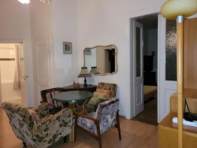 a living room with a table and chairs and a mirror at Bright 2BDR sleeps 8 near center M1 in Prague