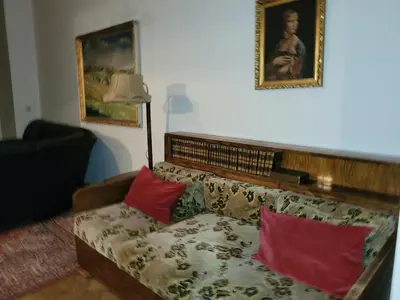 a living room with a couch with two red pillows at Bright 2BDR sleeps 8 near center M1 in Prague