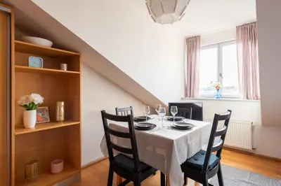 a dining room with a white table and chairs at Morya Sky Apartment in Prague