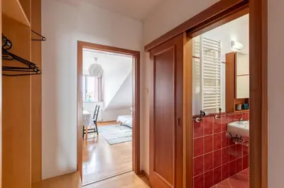 a hallway with a bathroom with a sink and a mirror at Morya Sky Apartment in Prague
