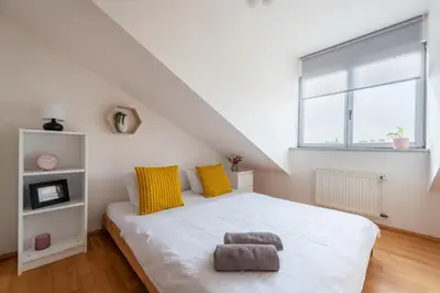 a bedroom with a large white bed with yellow pillows at Morya Sky Apartment in Prague