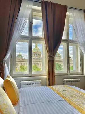 a bedroom with a window with a view of a building at Prague 1 Center Elegant 2BR Apartment with Panoramic Museum View and King Bed in Prague