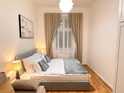 a bedroom with a bed in front of a window at Prague 1 Center Elegant 2BR Apartment with Panoramic Museum View and King Bed in Prague