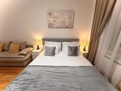 a living room with a bed and a couch at Prague 1 Center Elegant 2BR Apartment with Panoramic Museum View and King Bed in Prague