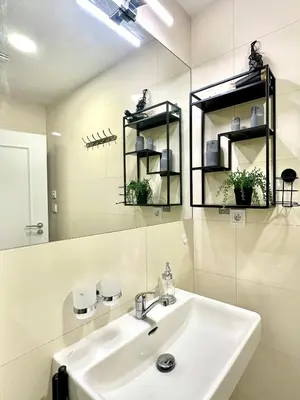 a white bathroom with a sink and a mirror at Prague 1 Center Elegant 2BR Apartment with Panoramic Museum View and King Bed in Prague