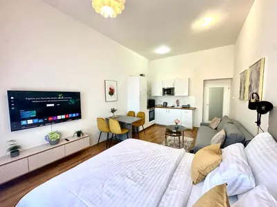 a bedroom with a large bed and a living room at Prague 1 Center Elegant 2BR Apartment with Panoramic Museum View and King Bed in Prague