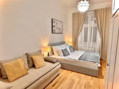 a living room with a couch and a bed at Prague 1 Center Elegant 2BR Apartment with Panoramic Museum View and King Bed in Prague