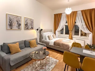 a living room with a couch and a bed at Prague 1 Center Elegant 2BR Apartment with Panoramic Museum View and King Bed in Prague