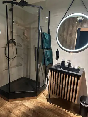 a bathroom with a shower and a sink with a mirror at TAVI Apart-Hotel in Nupaky