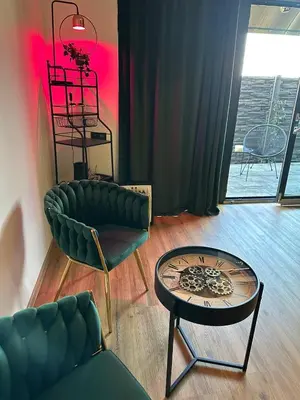 a living room with a green couch and a table at TAVI Apart-Hotel in Nupaky