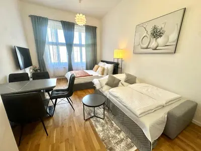 a living room with a couch and a table and a piano at Prague 1 Center Modern 2BR Apartment with Panoramic Museum View and King Bed in Prague