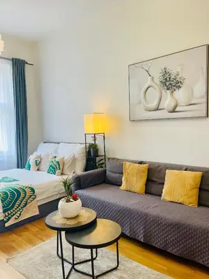 a living room with a couch and a table at Prague 1 Center Modern 2BR Apartment with Panoramic Museum View and King Bed in Prague