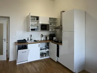 a kitchen with white cabinets and a white refrigerator at Prague 1 Center Modern 2BR Apartment with Panoramic Museum View and King Bed in Prague