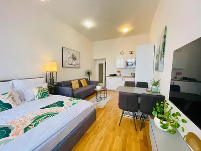 a bedroom with a bed and a living room at Prague 1 Center Modern 2BR Apartment with Panoramic Museum View and King Bed in Prague