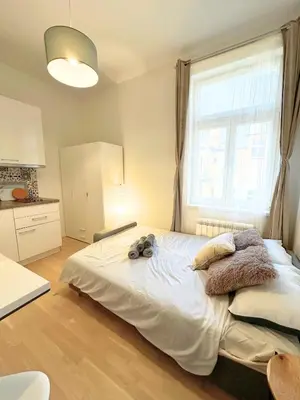 a bedroom with a large bed with a window at Small City Apartment in Prague