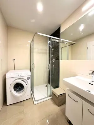 a bathroom with a washing machine and a shower at Small City Apartment in Prague