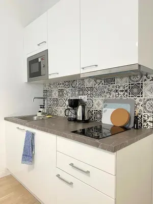 a kitchen with white cabinets and a counter top at Small City Apartment in Prague