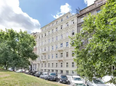 a large building with cars parked in front of it at Small City Apartment in Prague
