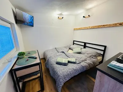 a small room with two beds and a table at Apartmán v klidné části Benešova in Benešov