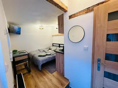 a small room with a bed and a mirror at Apartmán v klidné části Benešova in Benešov