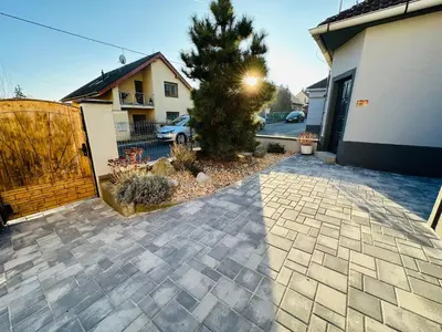 a driveway of a house with a fence and a tree at Apartmán v klidné části Benešova in Benešov