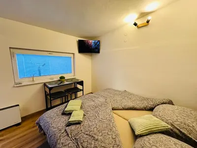 a bedroom with a bed and a window and a desk at Apartmán v klidné části Benešova in Benešov