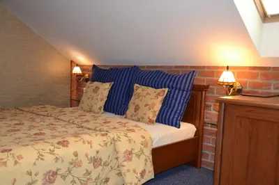 a bedroom with a bed with blue pillows at Penzion Aurooms in Zlatníky