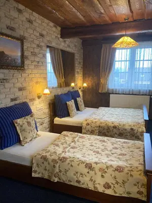 a hotel room with two beds and two windows at Penzion Aurooms in Zlatníky