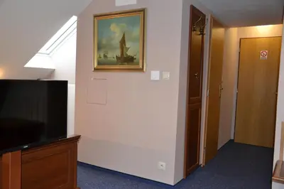 a room with a television and a painting on the wall at Penzion Aurooms in Zlatníky