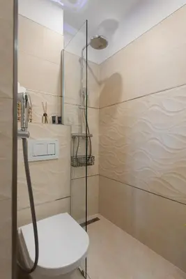 a shower with a white chair in a bathroom at Sunset View Apartment in Prague
