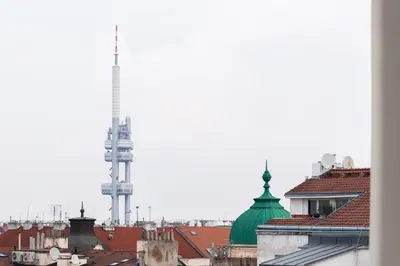 a view of a city with roofs and a tv tower at Sunset View Apartment in Prague