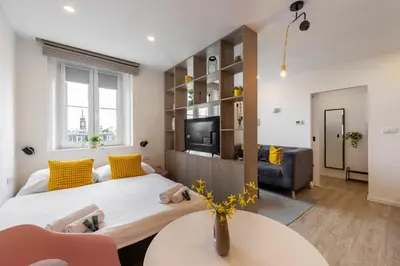 a living room with a bed and a table and a couch at Sunset View Apartment in Prague