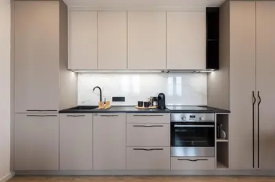 a white kitchen with stainless steel appliances and white cabinets at Sunset View Apartment in Prague
