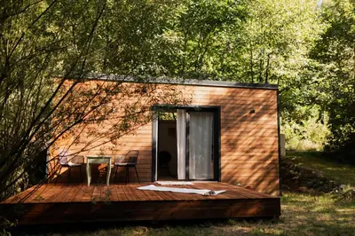 a small cabin with a table and chairs on a deck at Buňka Poteplí in Horní Bezděkov
