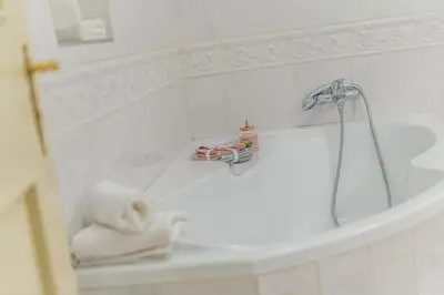 a white bathroom with a tub and a towel at Luxury Karmelitska 2B apartment in Prague