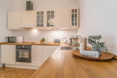 a kitchen with white cabinets and a wooden cutting board at Luxury Karmelitska 2B apartment in Prague