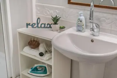 a bathroom with a sink and a shelf with towels at Luxury Karmelitska 2B apartment in Prague
