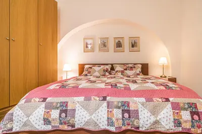 a bedroom with a bed with a quilt on it at Karmelitska 1 luxury 1 bedroom in Prague